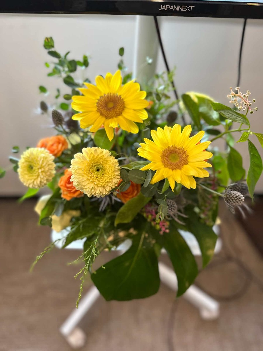 修了式の教室に飾られた、ひまわりを中心とした黄色とオレンジの花束